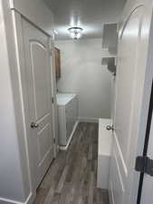 Washroom with dark wood-type flooring, cabinets, washer and clothes dryer, and a textured ceiling