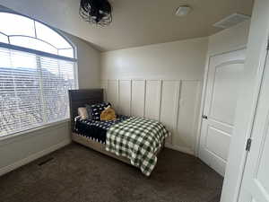 Bedroom featuring vaulted ceiling and dark colored carpet