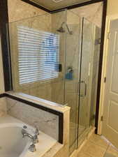 Bathroom featuring tile patterned flooring and shower with separate bathtub