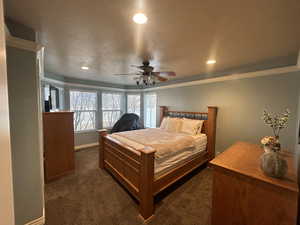 Carpeted bedroom featuring crown molding and ceiling fan