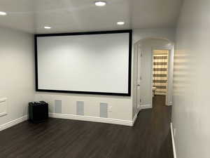 Cinema room with dark hardwood / wood-style flooring