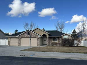 Single story home featuring a garage and a front lawn