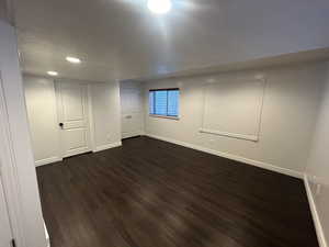 Basement with dark wood-type flooring