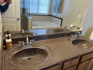 Bathroom featuring vanity and tiled bath