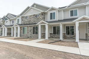 View of property featuring a porch and stone siding
