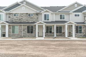 Multi unit property featuring board and batten siding, covered porch, and stone siding