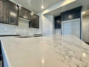 Kitchen with dark brown cabinets and light stone counters