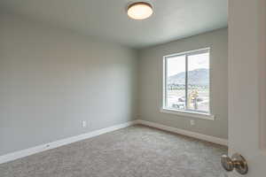 Spare room featuring carpet floors, baseboards, and a mountain view