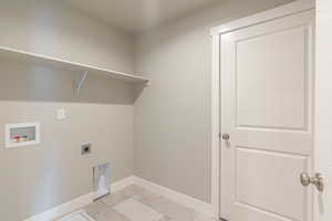 Laundry area featuring laundry area, marble finish floor, baseboards, hookup for a washing machine, and hookup for an electric dryer