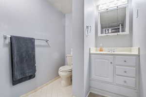 Bathroom with vanity, tile patterned floors, and toilet