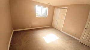 Unfurnished bedroom with a closet and carpet