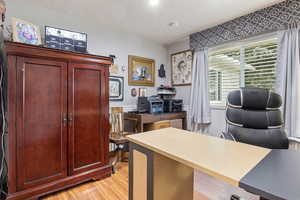 Office space with light hardwood / wood-style flooring