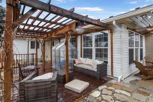 Deck with a pergola and outdoor lounge area