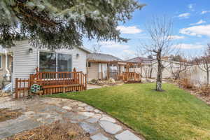 View of yard with a wooden deck and a patio area