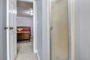 Bathroom featuring an enclosed shower and a textured ceiling