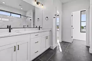 Bathroom with a shower with door, vanity, and tile patterned flooring