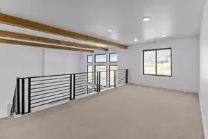 Carpeted spare room featuring beamed ceiling and plenty of natural light