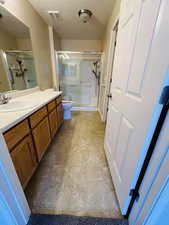 Bathroom with large vanity,  a shower with door, and toilet