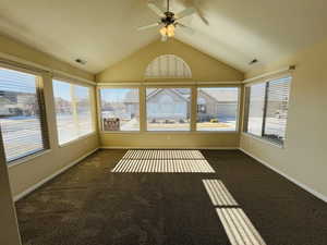 Beautifully lit sunroom featuring ceiling fan and vaulted ceiling