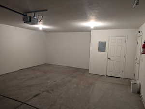 Deep Garage with a garage door opener and electric panel