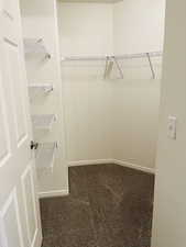 Spacious master closet with mid-color carpet