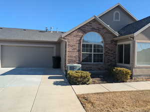 View of front of house with a garage and central AC unit