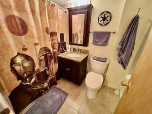 Bathroom featuring vanity, tile patterned floors, and toilet