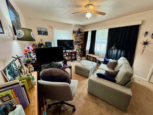 Living room with ceiling fan and a textured ceiling