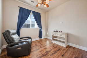 Sitting room featuring dark hardwood / wood-style flooring and ceiling fan