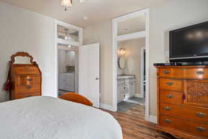 Bedroom featuring dark hardwood / wood-style flooring, sink, washing machine and clothes dryer, and ensuite bathroom