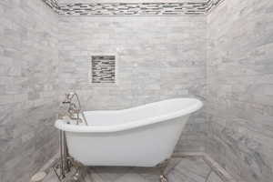 Bathroom featuring tile walls and a bathtub