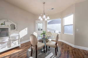 Dining area featuring dark hardwood / wood-style floors and a chandelier