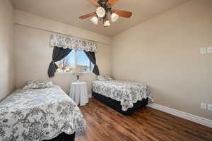 Bedroom featuring ceiling fan and dark hardwood / wood-style flooring