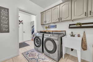 Laundry room with shelving, cabinets, and utility sink directly off the garage