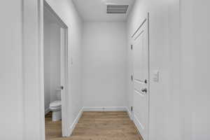 Hallway with light hardwood / wood-style floors