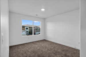 Unfurnished room featuring dark colored carpet