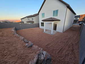 Back house at dusk with a patio area