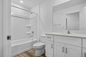 Full bathroom with vanity, hardwood / wood-style floors, shower / bathtub combination, and toilet