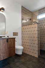 Bathroom with walk in shower, vanity, toilet, and tile patterned flooring