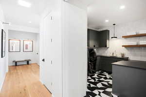 Interior space with sink, decorative backsplash, washer / dryer, and hanging light fixtures