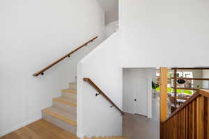 Stairway featuring hardwood / wood-style flooring and a high ceiling