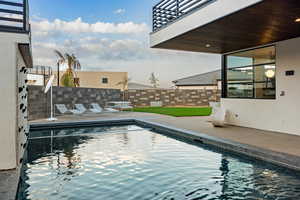 View of swimming pool with a lawn and a patio