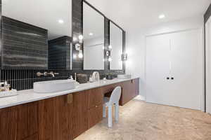 Bathroom featuring vanity and decorative backsplash