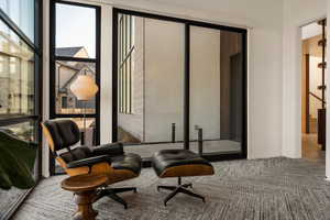 Sitting room featuring carpet and a wall of windows