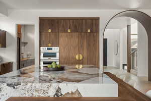 Kitchen with double oven and light stone countertops