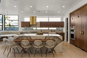 Kitchen featuring a kitchen island, a breakfast bar, sink, and hanging light fixtures