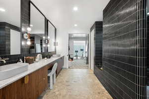 Bathroom with tile walls, vanity, and backsplash