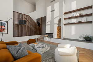 Living room with light parquet flooring and a towering ceiling