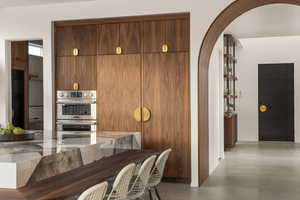 Kitchen with light stone countertops and double oven