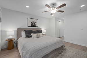 Bedroom with light hardwood / wood-style flooring, a closet, and ceiling fan